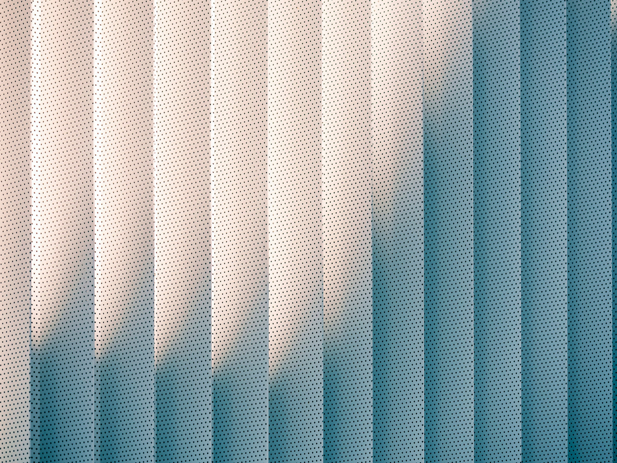 photo-wallpaper-perforated-metal-facade-with-louvres-in-teal-and-blush-light